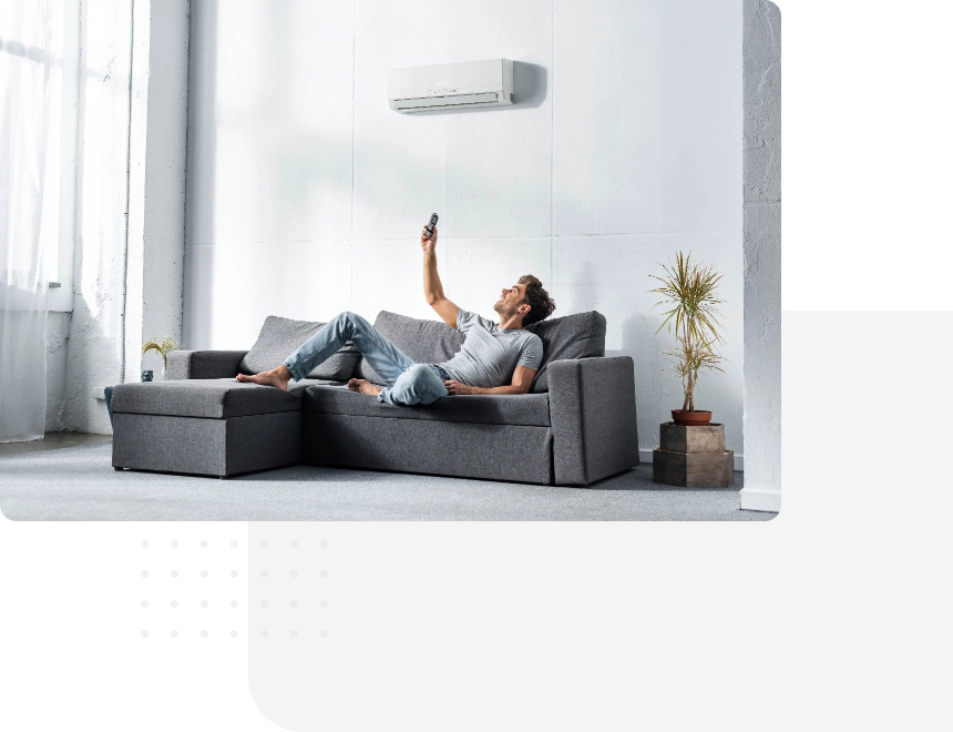Montaż klimatyzacji wykonany przez naszą firmę. Klimatyzacja zamontowana w luksusowym mieszkaniu, mężczyzna na kanapie.